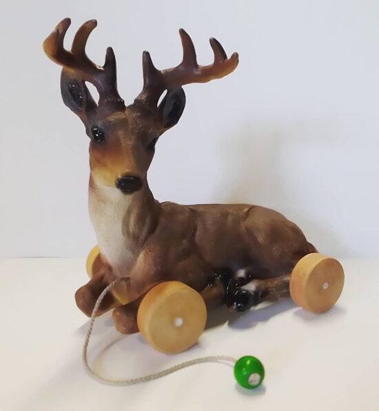 Daim en bois sur roulettes