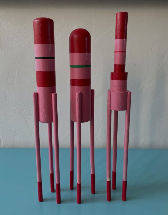 Trio de sculptures en bois rouges et roses